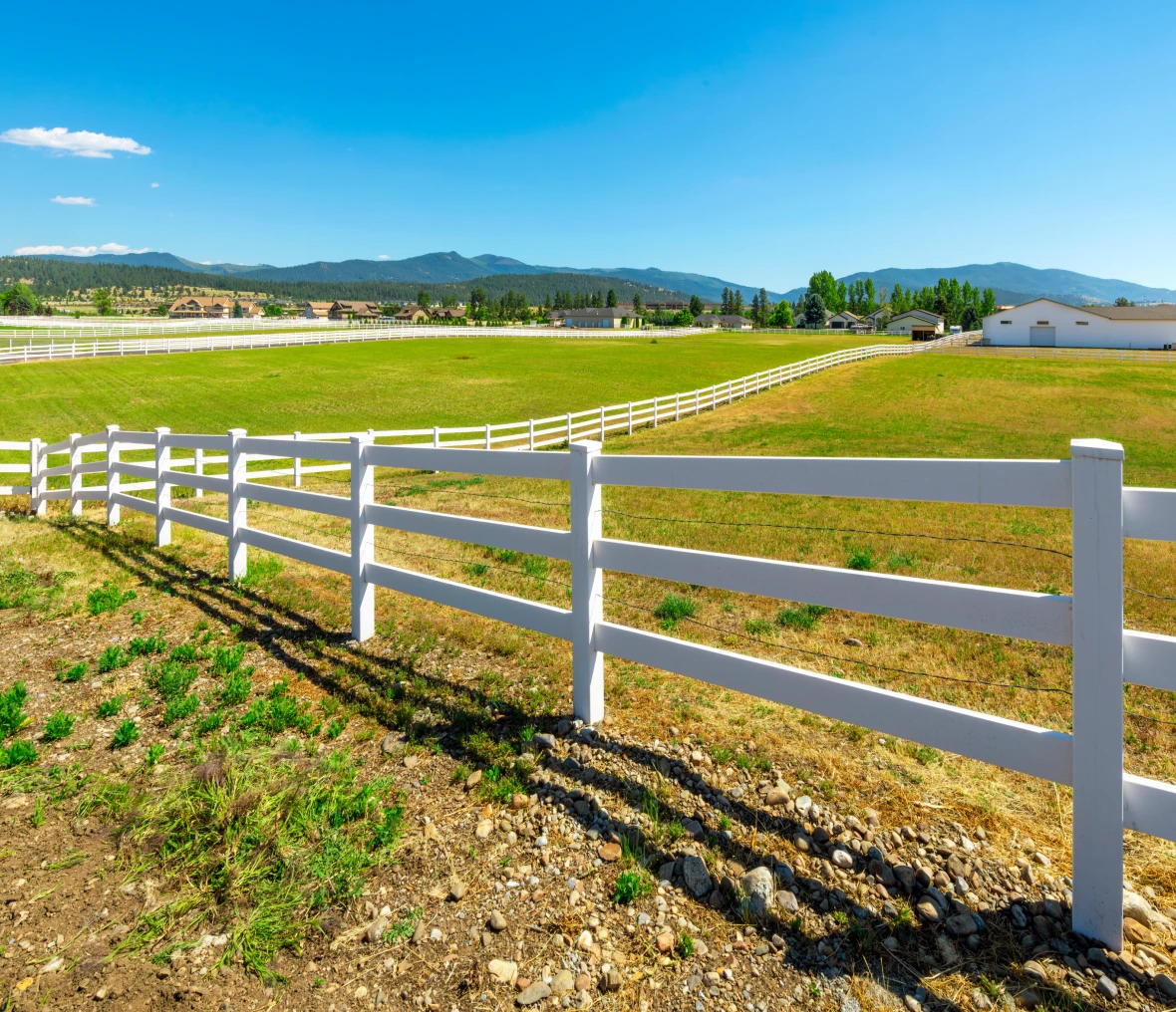 White fence along a scenic rural landscape.